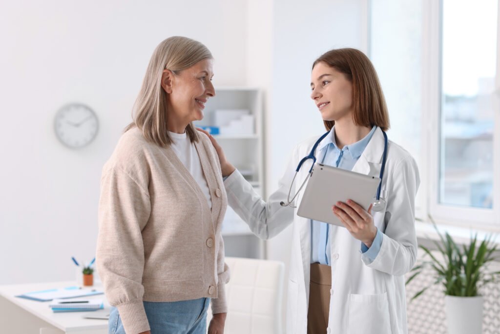 A doctor reassures a smiling patient during a consultation.