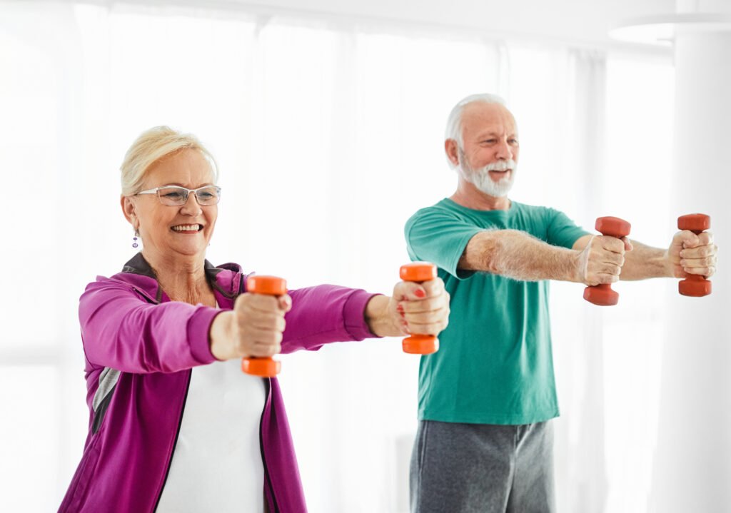 Senior couple exercise stretching and exercising with dumbbell lifting weigth at home health care